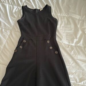 Black sleeveless jumpsuit with pockets and brown buttons